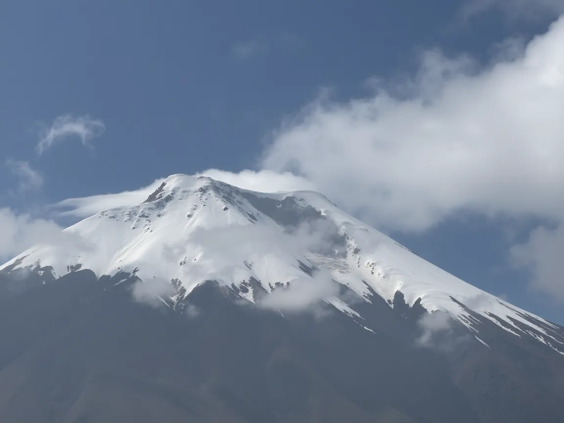 Volcán Cotopaxi nevado al amanecer con páramo andino y nubes bajas